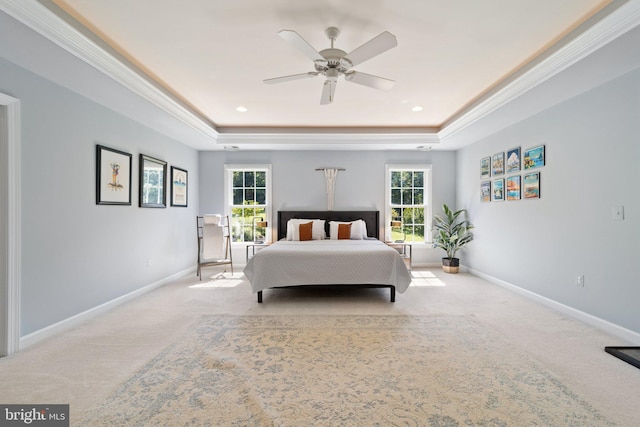 carpeted bedroom with ceiling fan, ornamental molding, a raised ceiling, and multiple windows