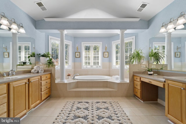 bathroom featuring tile patterned floors, tiled bath, decorative columns, and vanity