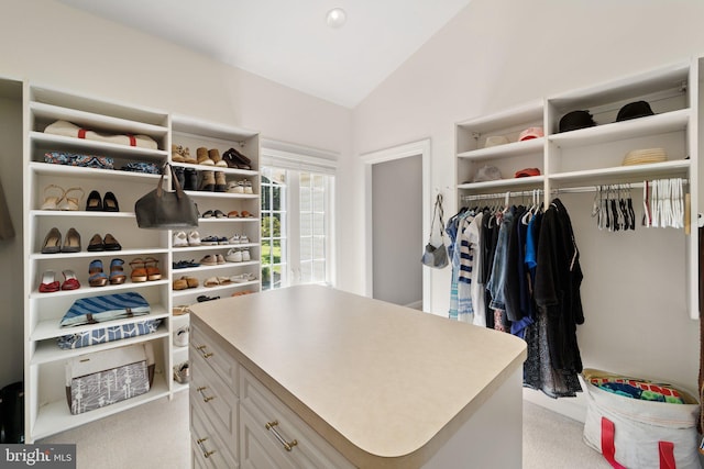 walk in closet with light carpet and vaulted ceiling