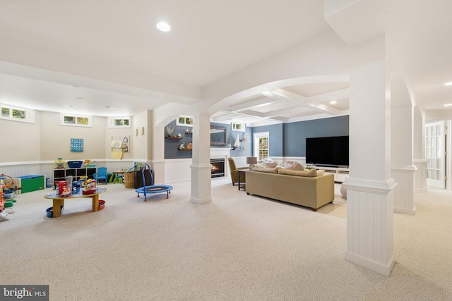 living room featuring beamed ceiling, coffered ceiling, light carpet, and ornate columns