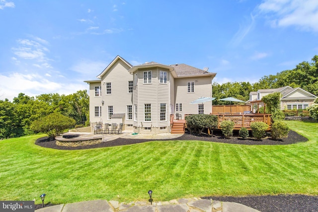 back of house with a wooden deck, a yard, and a patio area