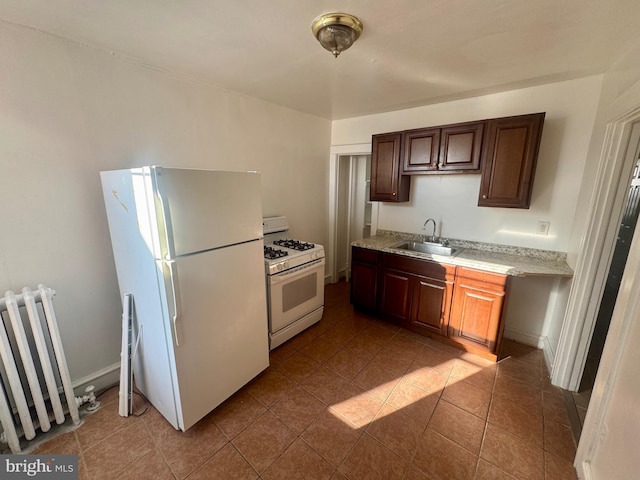 kitchen featuring tile patterned floors, sink, white appliances, and radiator heating unit