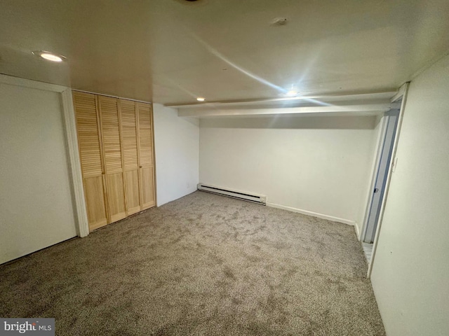 basement featuring carpet floors and a baseboard heating unit