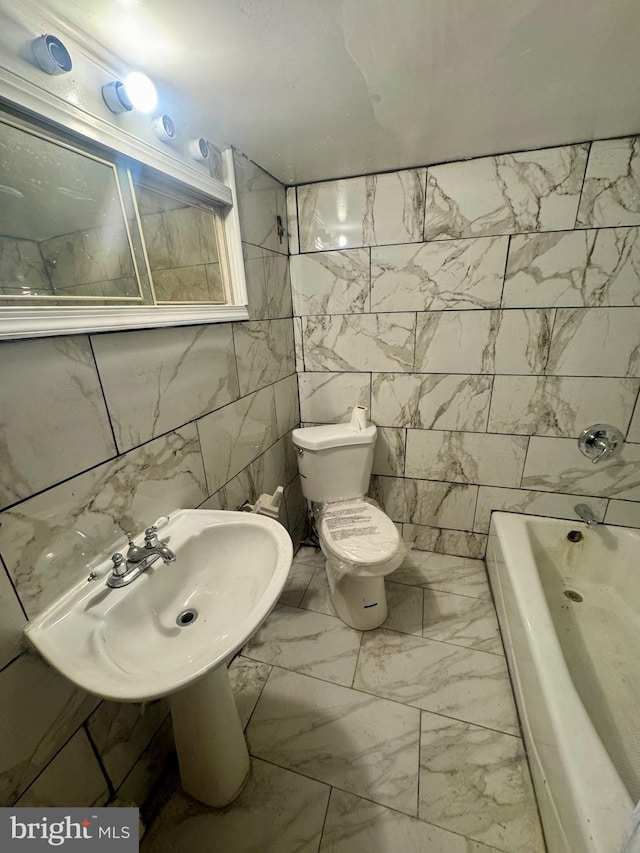 bathroom with toilet, tile walls, and sink