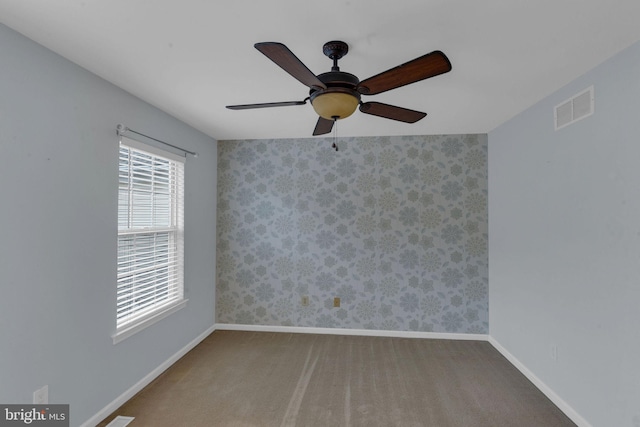 carpeted empty room featuring ceiling fan