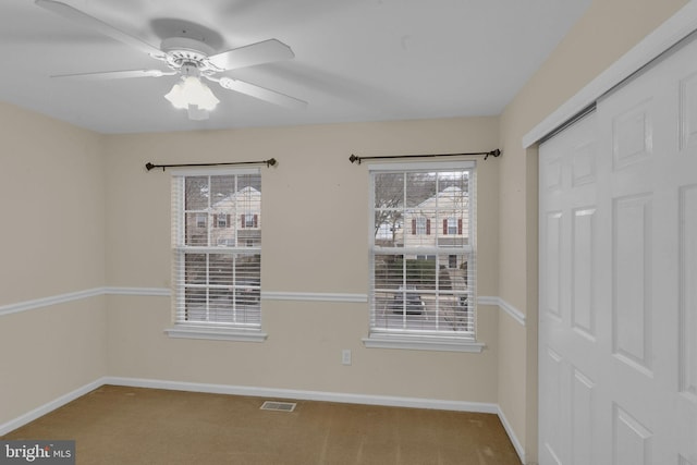 carpeted spare room with ceiling fan