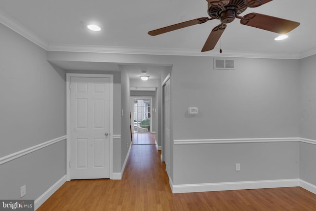 corridor featuring light wood-type flooring and crown molding