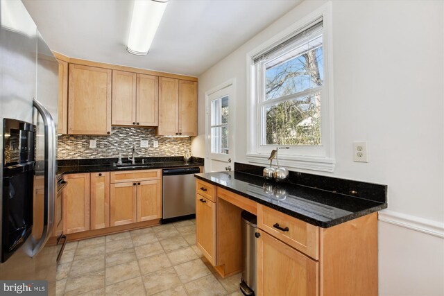 kitchen featuring sink, tasteful backsplash, dark stone counters, and appliances with stainless steel finishes