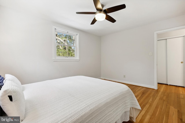 bedroom with hardwood / wood-style floors, a closet, and ceiling fan