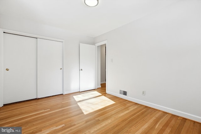 unfurnished bedroom featuring light hardwood / wood-style floors and a closet