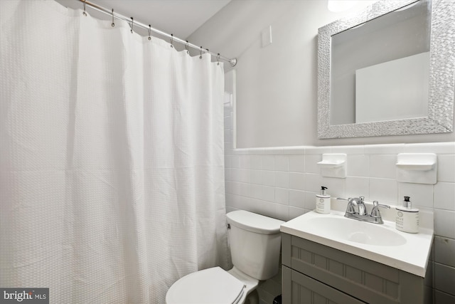 bathroom featuring tile walls, curtained shower, vanity, and toilet