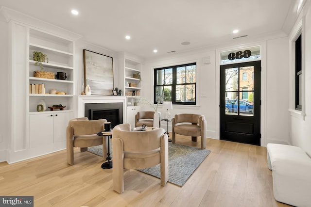 sitting room featuring light wood-style flooring, recessed lighting, a fireplace, and visible vents