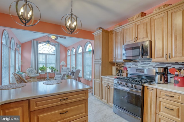 kitchen featuring lofted ceiling, decorative light fixtures, stainless steel appliances, tasteful backsplash, and a chandelier