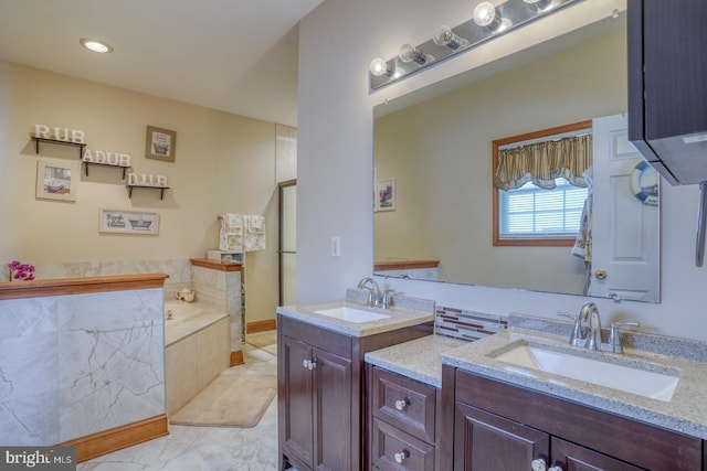 bathroom featuring tiled bath and vanity