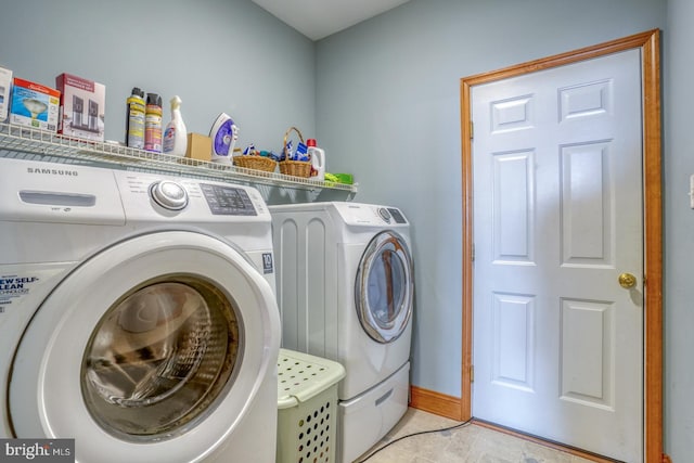 clothes washing area with washing machine and dryer and light tile patterned flooring