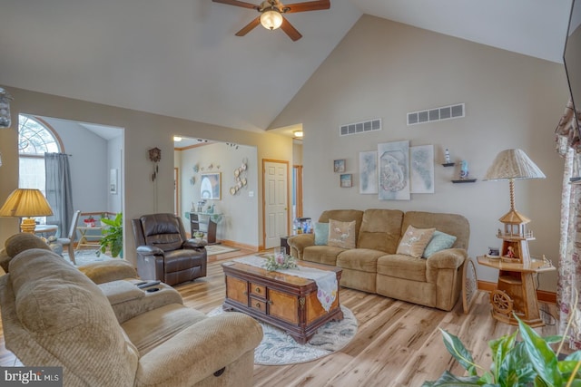 living room featuring ceiling fan, high vaulted ceiling, and light hardwood / wood-style flooring