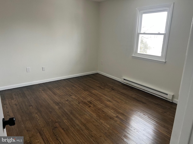 empty room with a baseboard heating unit and dark hardwood / wood-style floors