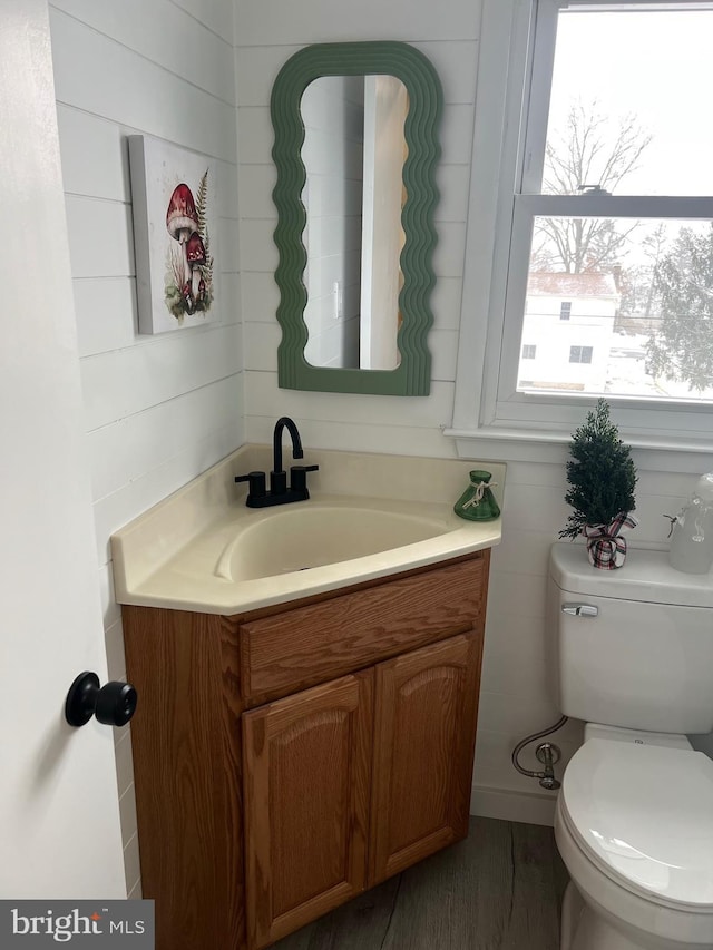 bathroom featuring toilet, vanity, and hardwood / wood-style flooring