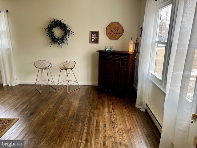 interior space featuring baseboard heating, bar area, and dark hardwood / wood-style flooring