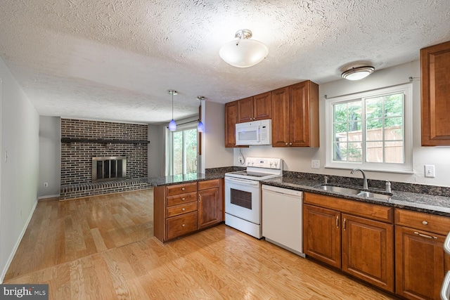 9416 Mirror Pond Dr, Fairfax, VA 22032 - kitchen with white appliances, a textured ceiling, brown cabinetry, a peninsula, and light wood-style floors