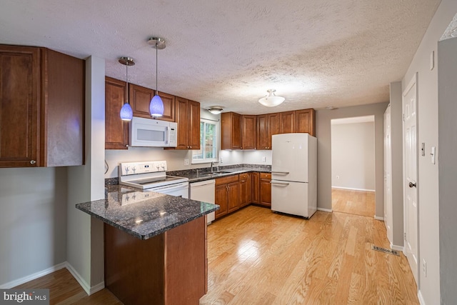 9416 Mirror Pond Dr, Fairfax, VA 22032 - kitchen with white appliances, a peninsula, light wood-type flooring, and a textured ceiling