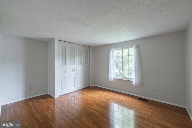 9416 Mirror Pond Dr, Fairfax, VA 22032 - unfurnished bedroom featuring hardwood / wood-style flooring, a textured ceiling, and a closet