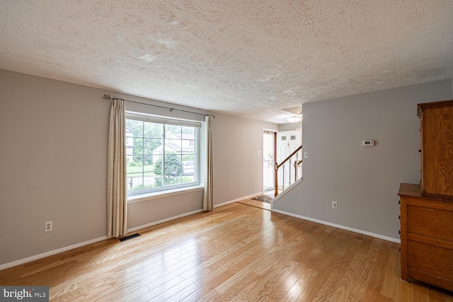 9416 Mirror Pond Dr, Fairfax, VA 22032 - spare room with a textured ceiling, light wood-type flooring, and stairs