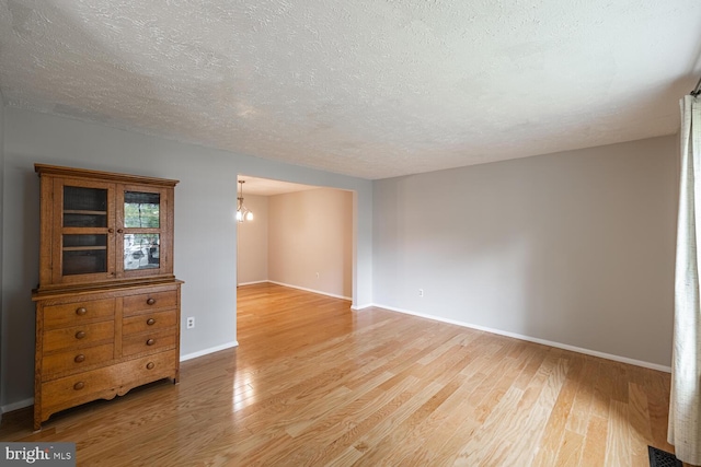 9416 Mirror Pond Dr, Fairfax, VA 22032 - empty room featuring a chandelier, light wood finished floors, and a textured ceiling