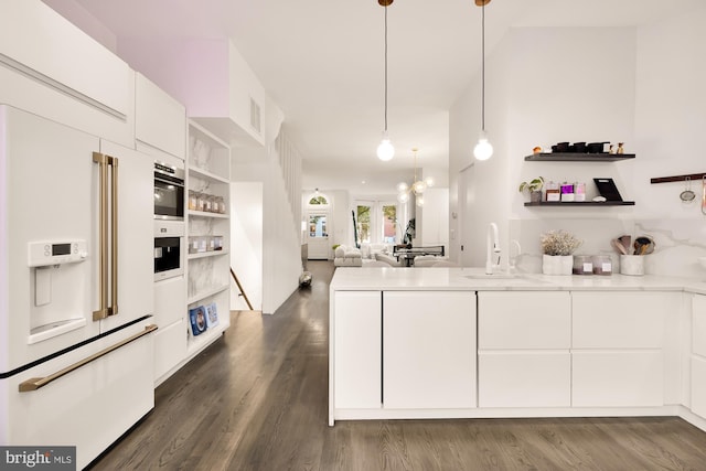 kitchen featuring high end white fridge, sink, white cabinets, dark hardwood / wood-style flooring, and hanging light fixtures