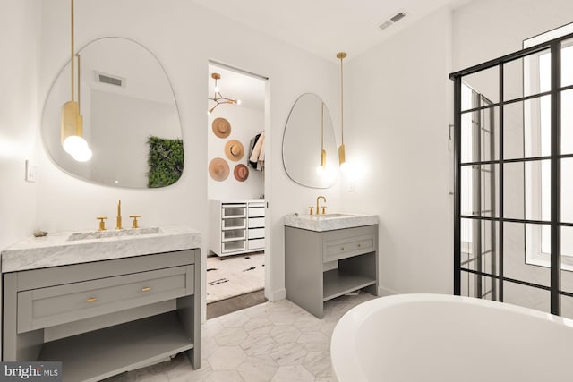 bathroom featuring tile patterned flooring, vanity, and a tub to relax in