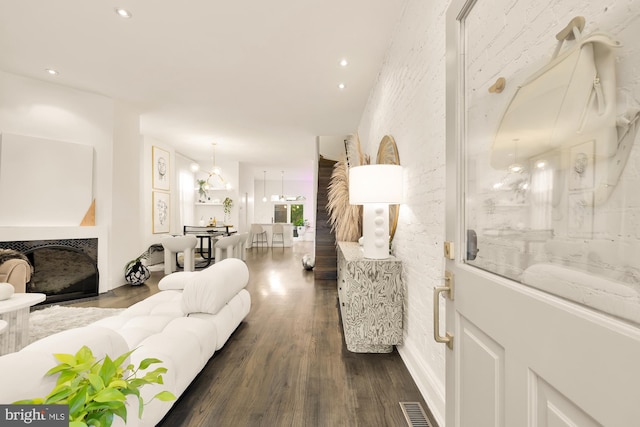 living room featuring an inviting chandelier and dark hardwood / wood-style floors