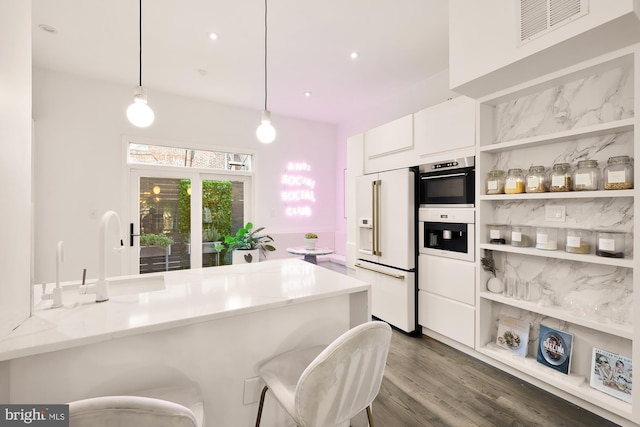 kitchen with sink, hanging light fixtures, white cabinets, high end white fridge, and kitchen peninsula