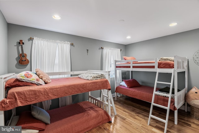 bedroom with light hardwood / wood-style floors and multiple windows