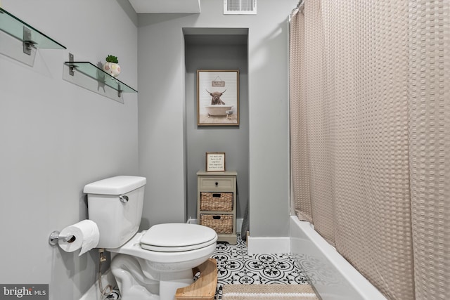 bathroom with shower / bathtub combination with curtain, tile patterned floors, and toilet