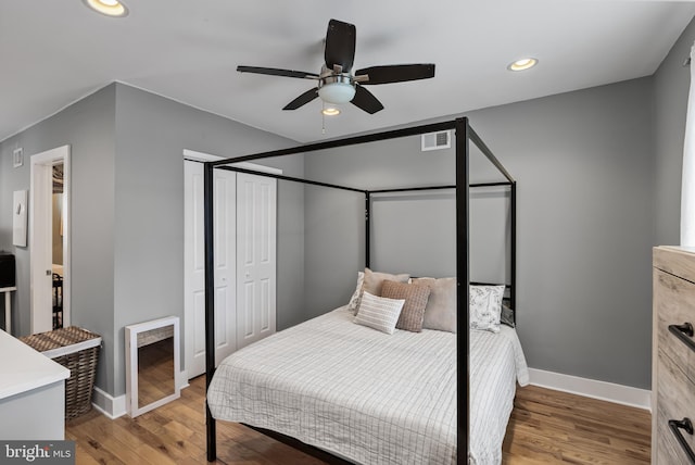 bedroom with ceiling fan, wood-type flooring, and a closet