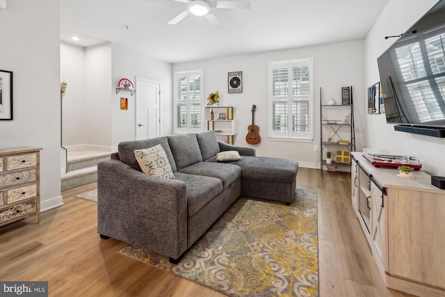 living room featuring a healthy amount of sunlight, ceiling fan, and light hardwood / wood-style flooring