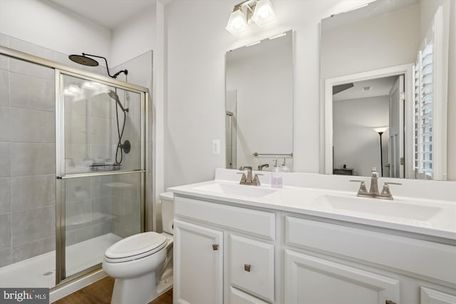 bathroom featuring vanity, hardwood / wood-style flooring, toilet, and walk in shower