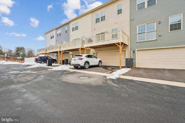 rear view of property featuring a garage and central AC unit