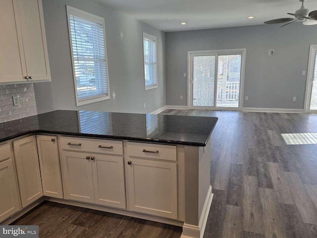 kitchen with dark hardwood / wood-style floors, white cabinetry, tasteful backsplash, and ceiling fan