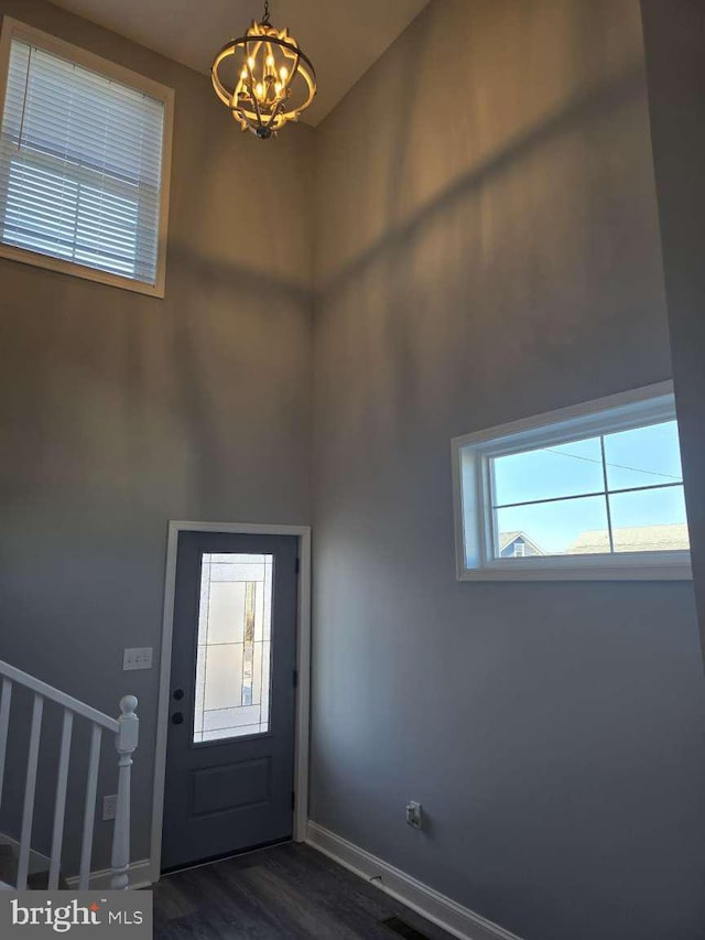 foyer with dark hardwood / wood-style flooring and a notable chandelier