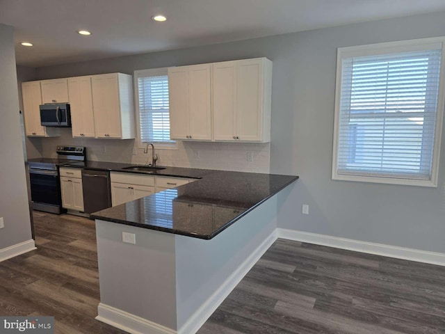 kitchen featuring kitchen peninsula, white cabinetry, sink, and appliances with stainless steel finishes