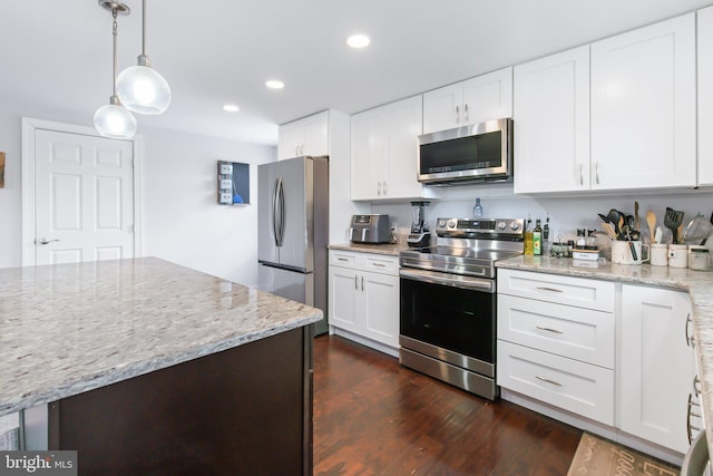 kitchen featuring white cabinetry, pendant lighting, stainless steel appliances, and light stone counters