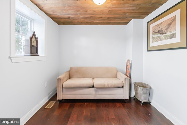 sitting room featuring dark wood-type flooring and wooden ceiling