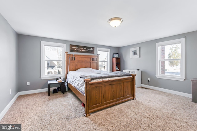 bedroom featuring multiple windows and light carpet