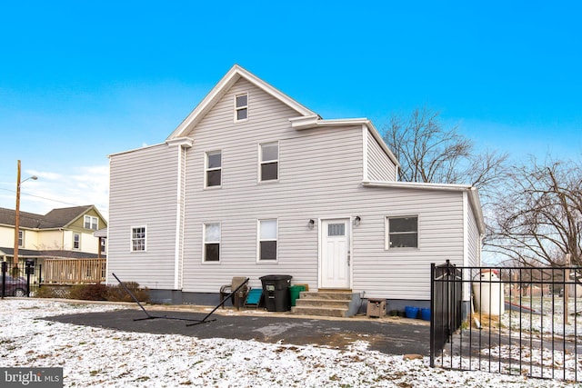 view of snow covered rear of property