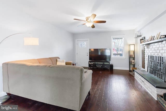 living room featuring dark hardwood / wood-style floors, a brick fireplace, and ceiling fan