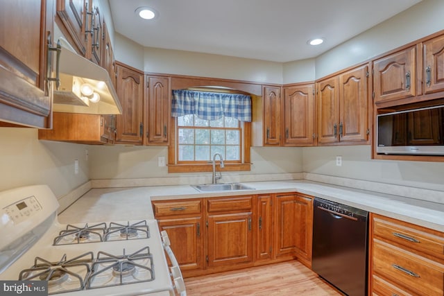 kitchen with white range oven, sink, light wood-type flooring, and black dishwasher