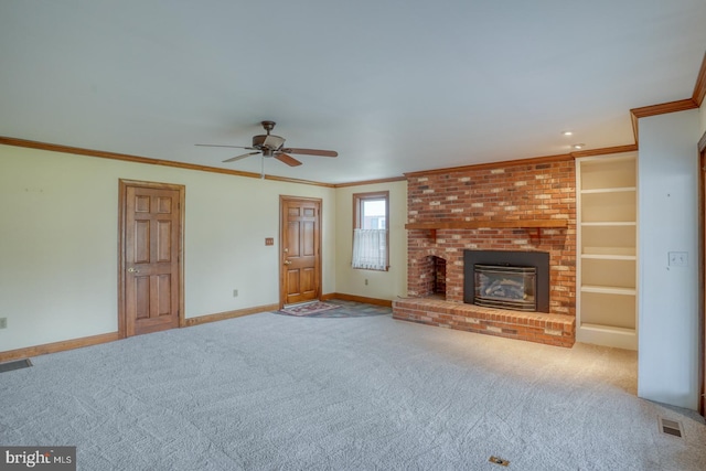 unfurnished living room featuring carpet flooring, ceiling fan, ornamental molding, and a brick fireplace