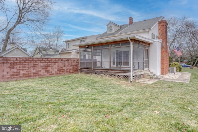 back of house with a sunroom and a yard