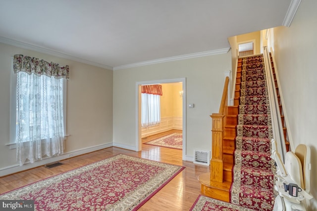 stairs featuring hardwood / wood-style flooring and ornamental molding